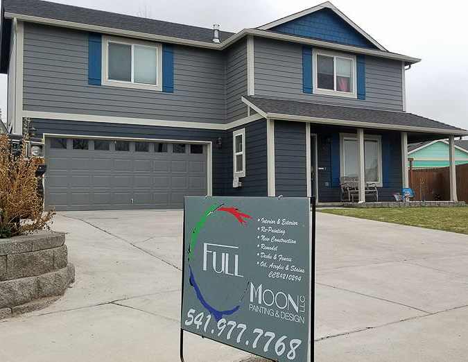 Finished exterior repaint, blue-gray two-story home with navy trim and a red garage door