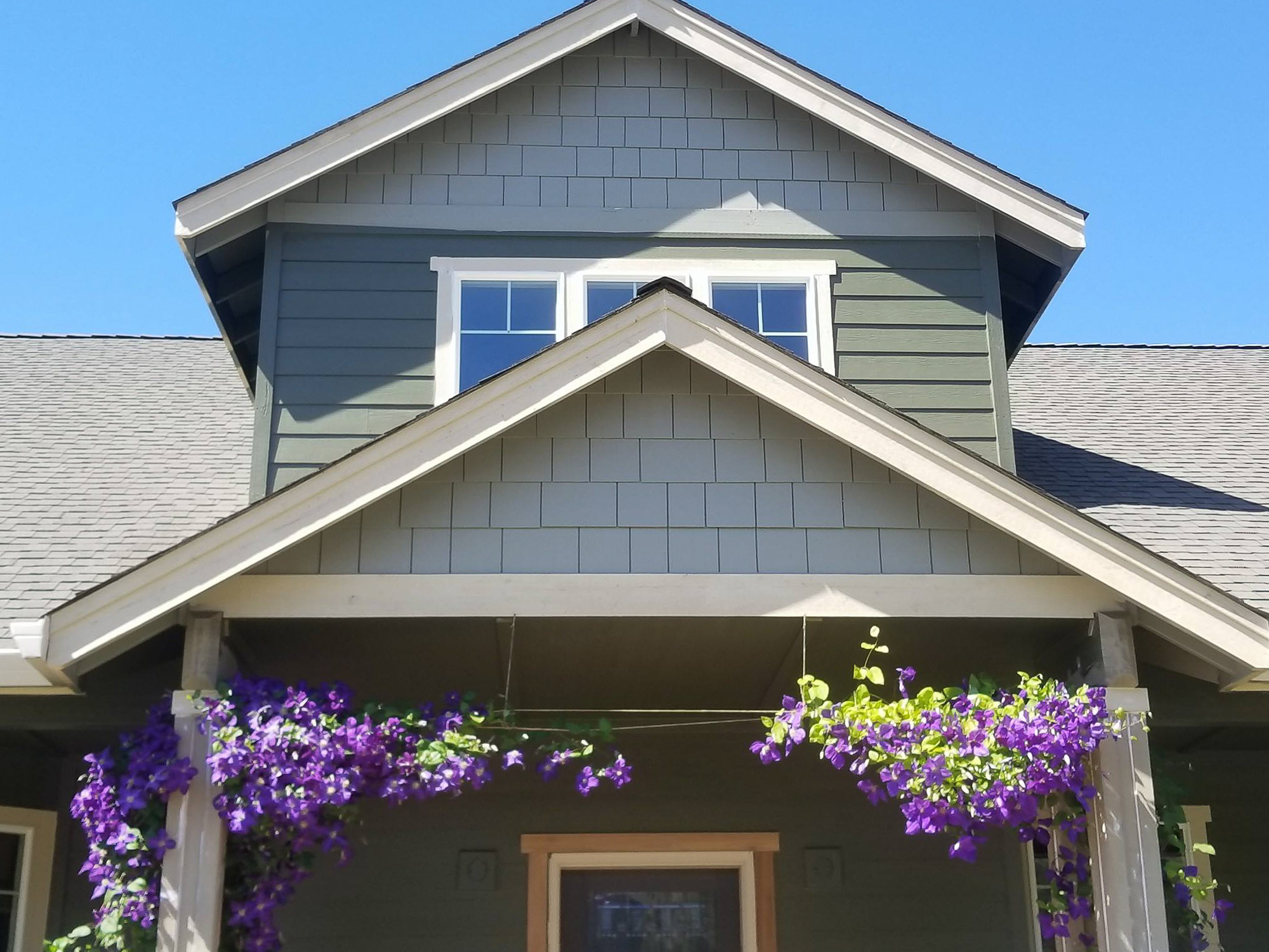 Close-up of a finished craftsman gable and dormer window above a covered porch